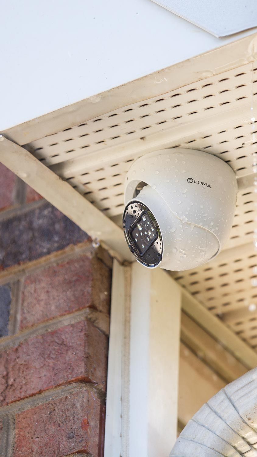 Outdoor security camera mounted under a house eave